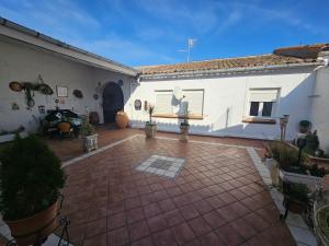 un patio de un edificio blanco con macetas en Casa Rural, en Valtierra