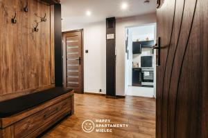een woonkamer met een houten deur en een keuken bij Happy Stay - Happy Apartamenty Mielec in Mielec