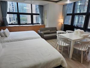 Cette chambre d'hôtel comprend deux lits, une table et des chaises. dans l'établissement Samseong,Coexmall A, à Séoul