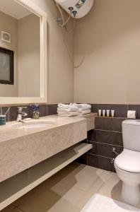 a bathroom with a toilet and a sink and a mirror at Vesta - El Gouna Residence in Hurghada