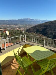 a green table and two chairs on a balcony at La Casa del Vento in Trebiano