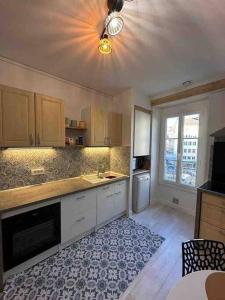 a kitchen with a ceiling fan and a kitchen with a table at Confortable T3 juste rénové au cœur d’Aurillac in Aurillac