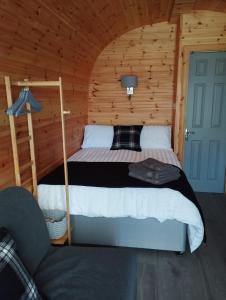 a bedroom with a bed in a wooden cabin at Aurora Skye in Breakish