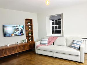 uma sala de estar com um sofá e uma televisão de ecrã plano em Lovely Spacious Apartment At Temple Bar em Dublin