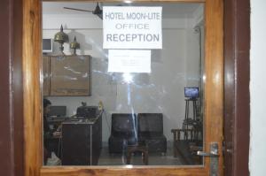 a person sitting at a desk in a room with a window at HOTEL MOON-LITE in Guwahati