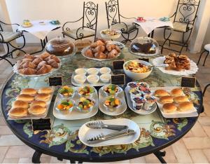 a table topped with plates of food and pastries at L'alloro room's affittacamere in Pachino