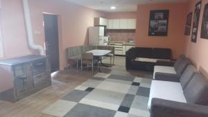 特雷比涅的住宿－Red Apartman，带沙发和桌子的客厅以及厨房。