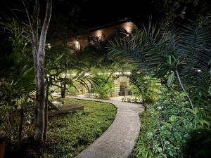 a walkway with a bench in a garden at night at aonangstudio 2 floor in Klong Muang Beach