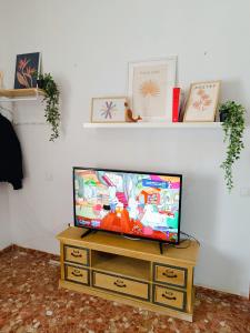 una TV a schermo piatto seduta sopra un comò in legno di Casa Completa Terraza Real de la Sierra Subbetica a Carcabuey
