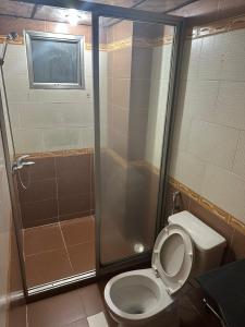 La salle de bains est pourvue de toilettes et d'une douche en verre. dans l'établissement Gia Bảo Hotel - 234/3 Bạch Đằng, Q.Bình Thạnh - by Bay Luxury, à Hô-Chi-Minh-Ville