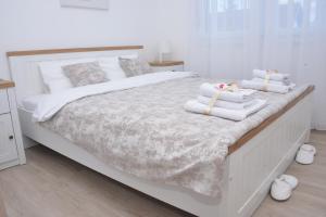 a bedroom with a white bed with towels on it at Bella in Sremska Mitrovica