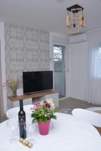 a living room with a table with wine glasses and a television at Bella in Sremska Mitrovica