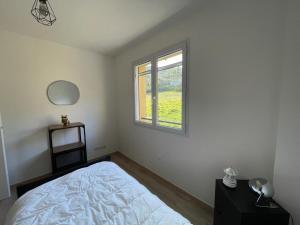 een slaapkamer met een bed en een raam bij Maison familiale au calme in Carros