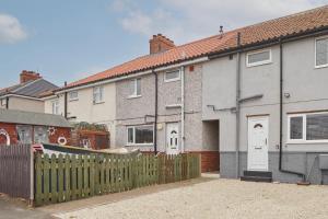 a house with a wooden fence in front of it at Hillside View Staithes in Staithes