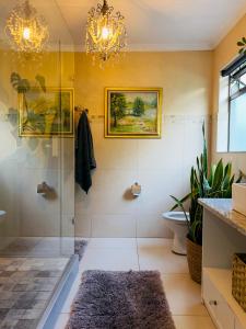 a bathroom with a shower and a chandelier at Art-Inspired Bedroom Close to CBD in Mossel Bay