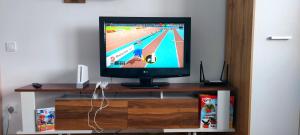 a flat screen tv sitting on top of a wooden shelf at DAS Home-Vedere la Muntii Bucegi parcare gratuita in Râşnov