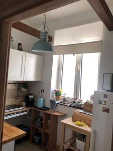 een keuken met een koelkast en een tafel en een aantal ramen bij Master Corner Apartment in Krakau