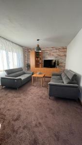 uma sala de estar com dois sofás e uma televisão em Casa Philippi em Montabaur