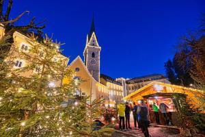 un mercato natalizio di fronte a una chiesa con una torre di Dolomites Smart Holidays a Valdaora