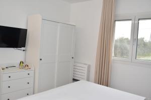 ein weißes Schlafzimmer mit einem Bett und einer Kommode in der Unterkunft I Secolari di Giulia 2 in Avola + 42 Fotos