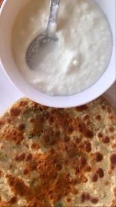 a bowl of milk and a bowl of food with a spoon at Badriniwas homestays in Almora