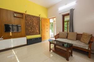a living room with a couch and a tv at Padma Bliss Guest House in Mangalore