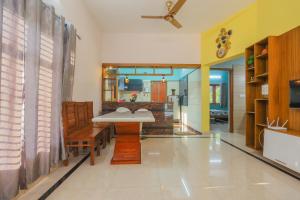 a living room with a table and a kitchen at Padma Bliss Guest House in Mangalore
