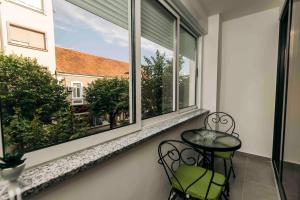 een balkon met een tafel en stoelen en een raam bij Rest in the center in Nikšić