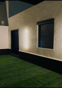 une chambre avec une porte, une fenêtre et de la pelouse dans l'établissement أجنحة لافينا الخاصة, à Yanbu