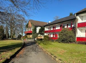 a house with a red and white building on a street at Ferienwohnung Hercules in Meinerzhagen
