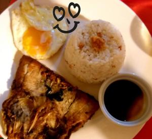 um prato de alimentos com um ovo e arroz em Forest Bay Inn El Nido em El Nido
