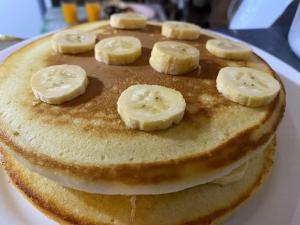 a stack of pancakes with banana slices on top at Forest Bay Inn El Nido in El Nido