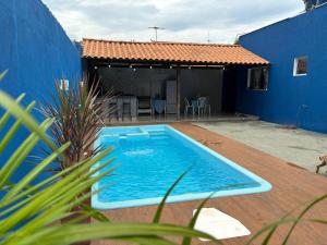 a blue house with a swimming pool in a yard at Casa com piscina perto do inhotim in Mario Campos