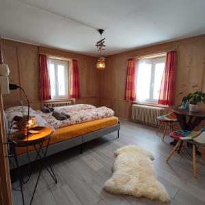 a bedroom with a bed and a rug on the floor at Haus Albula in Alvaneu
