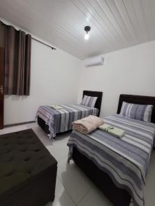 リオ・デ・コンタスにあるPousada Portal da Chapadaのベッド2台とソファが備わる客室です。