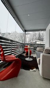 a living room with a red chair and a couch at Grüenipark Davos in Davos