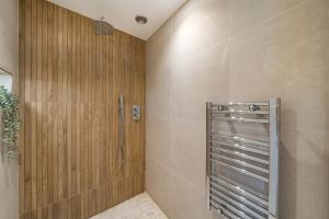 a shower stall in a bathroom with wooden walls at Romantic getaway UK with Private Sauna, King Bed, WiFi 517mbps & EV Charger in Woking