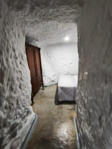 um pequeno quarto com uma cama numa parede de pedra em Cueva de David 