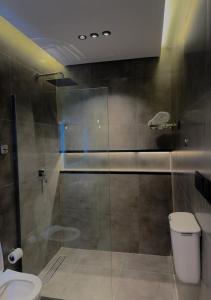 La salle de bains est pourvue d'une douche en verre et de toilettes. dans l'établissement أجنحة لافينا الخاصة, à Yanbu