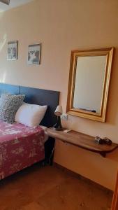 1 dormitorio con cama y espejo en la pared en Aluse Beach, en Los Alcázares