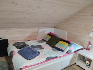 a bed with pillows on it in a room at Dom nad wodospadem in Kletno