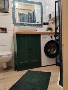 a bathroom with a sink and a washing machine at Dom nad wodospadem in Kletno