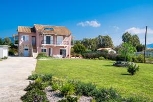 a house with a lawn in front of it at Ruellia Luxury Apartments in Lefkada Town