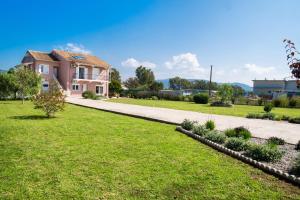 a house with a lawn and a sidewalk at Ruellia Luxury Apartments in Lefkada Town