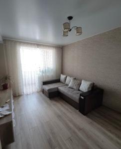 a living room with a couch and a window at Ciocana apartament in Chişinău