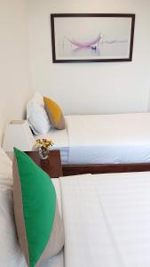 1 dormitorio con 2 camas y una foto en la pared en Hoi An Four Seasons Villa en Hoi An