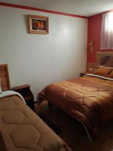 1 dormitorio con 2 camas en una habitación en Hostal Ñuca Huasi, en Tambillo