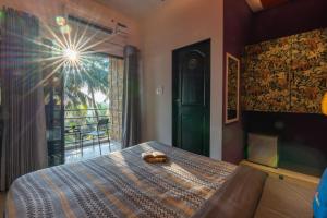 a bedroom with a bed with a view of a balcony at Whoopers Boutique Morjim in Morjim