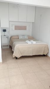 1 dormitorio con 1 cama con 2 toallas en Monoambiente Atenea B en Chivilcoy