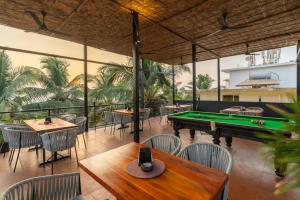 a restaurant with a pool table and tables and chairs at Whoopers Boutique Morjim in Morjim
